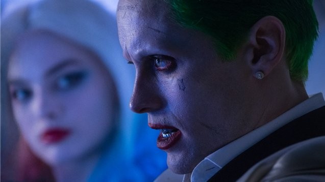 A shot from the film "Suicide Squad" where Jared Leto as the Joker is seen on the foreground, and Margot Robbie as Harley Quinn in the background.