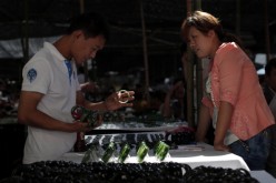 A customer selects jade bracelets at the Shifosi early market on May 27, 2013, in Shifosi town of Henan Province, China.