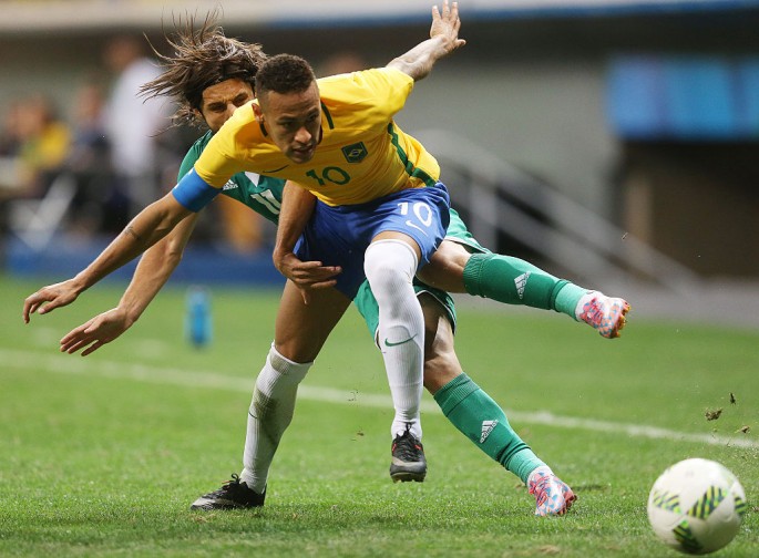 Brazil forward Neymar competes for the ball against an Iraqi defender.