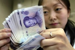 A bank employee counts new 5-yuan (60 U.S. cents) bank notes in Beijing.