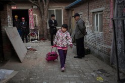 A member of a Beijing family leaves their apartment which will be demolished to give way to an expansion plan.