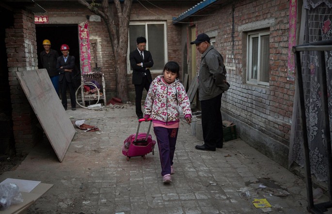 A member of a Beijing family leaves their apartment which will be demolished to give way to an expansion plan.