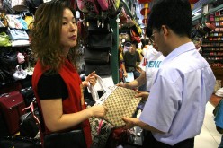 Beijing's Silk Alley, famous for selling imitation and fake bags, has signed an agreement with big-name international brands like Louis Vuitton and Gucci not to sell fake versions of their products.