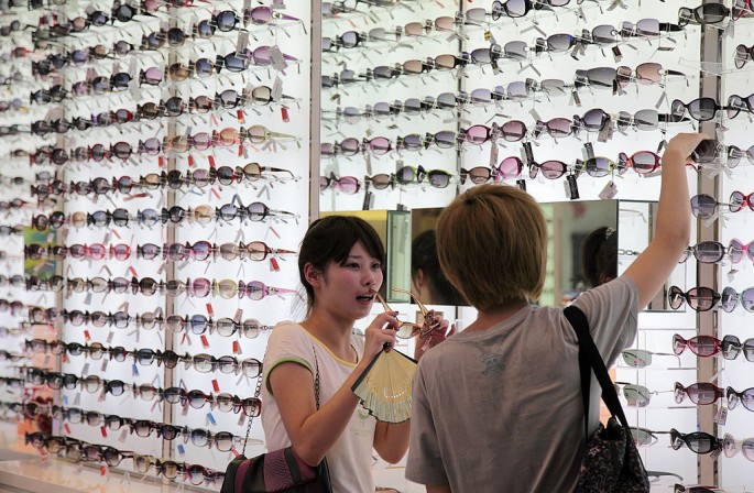 Customers look at sunglasses on sale in a retail store in China.