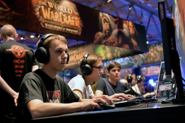 Visitors try out the massively multiplayer online role-playing game 'World Of Warcraft' at the Blizzard Entertainment stand at the 2014 Gamescom gaming trade fair on August 14, 2014 in Cologne, German