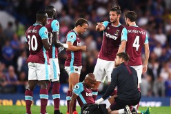 West Ham players gather around new-signing Andre Ayew (sitting) after the forward suffered a thigh injury in their match against Chelsea.