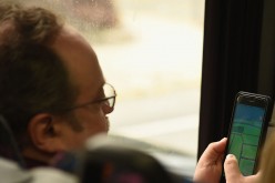 A man plays Pokemon Go while on the bus in New York City.