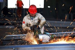 A worker polishing metal in a steel factory in Rizhao in Shandong Province.