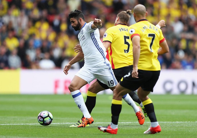 Chelsea striker Diego Costa (#19) competes for the ball against two Watford defenders.