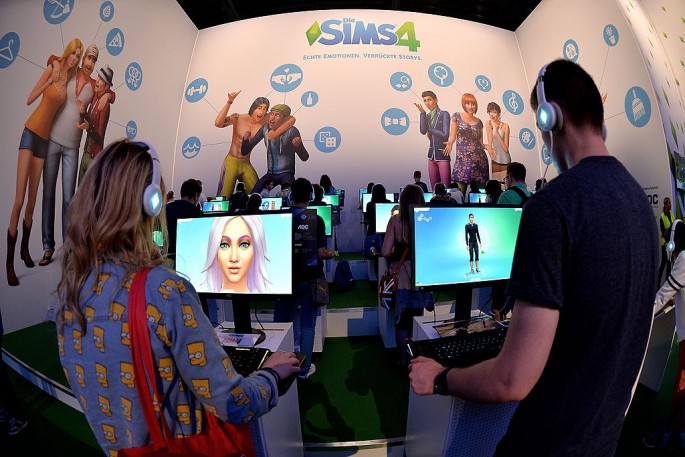 Visitors try out the game 'SIMS 4' at the Electronic Arts stand at the 2014 Gamescom gaming trade fair on August 14, 2014 in Cologne, Germany. 