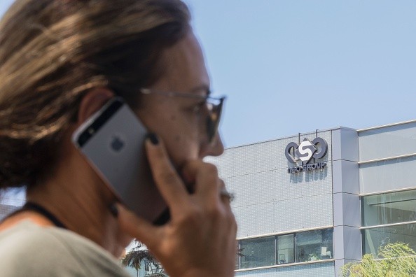 An Israeli woman uses her iPhone in front of the building housing the Israeli NSO group, in Herzliya, near Tel Aviv on August 28, 2016