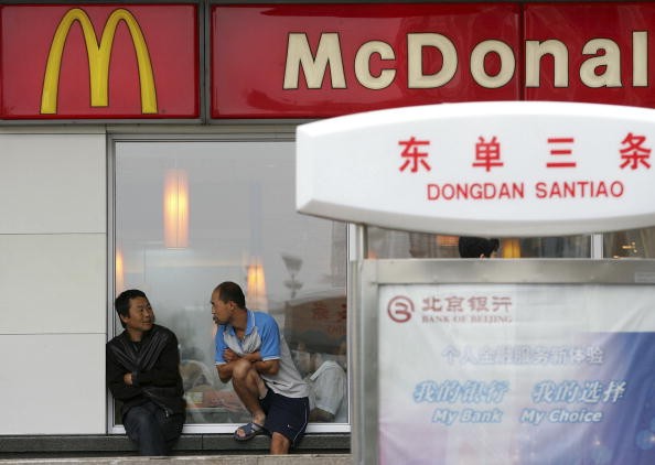 A fast food restaurant worker takes a break at Wangfujing Commercial Street on July 25, 2006 in Beijing, China.