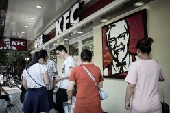 Customers walk outside a KFC restaurant in Shanghai. KFC is under the Yum! Brands Inc.