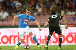 Napoli striker Arkadiusz Milik (L) competes for the ball against Roma's Alessio Romagnoli.