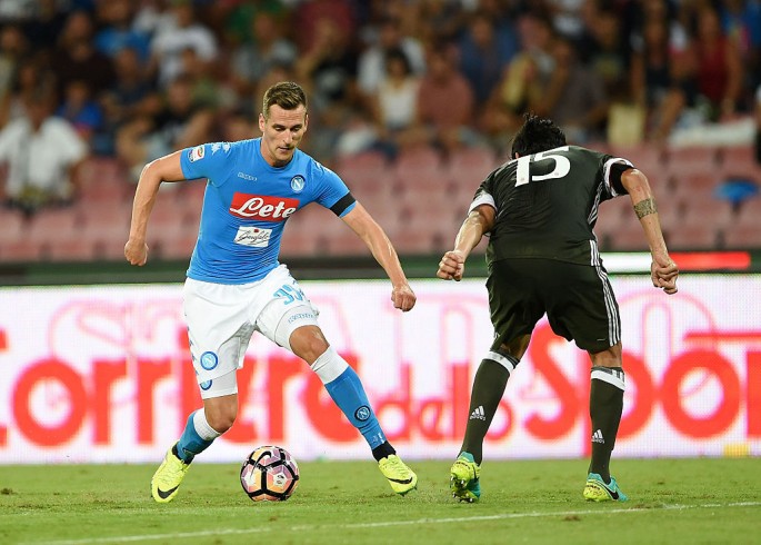 Napoli striker Arkadiusz Milik (L) competes for the ball against Roma's Alessio Romagnoli.
