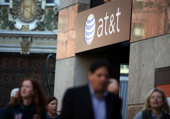 Pedestrians walk by an AT&T store on October 23, 2013 in San Francisco, California. 