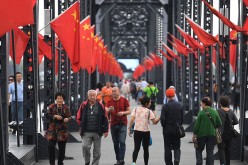 Tourists walk on the Chinese side of the Broken Bridge, which once connected China and North Korea, at the Chinese border city of Dandong.