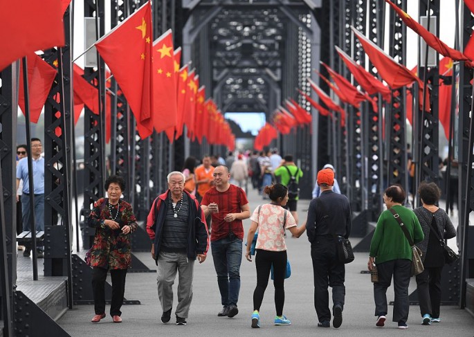 Tourists walk on the Chinese side of the Broken Bridge, which once connected China and North Korea, at the Chinese border city of Dandong.