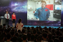 Chinese female taikonaut Wang Yaping answers a  student's question from Tiangong-1 space module in June 2013.