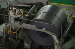 A worker unloads a roll of steel sheet in Baosteel steel mill in Shanghai.
