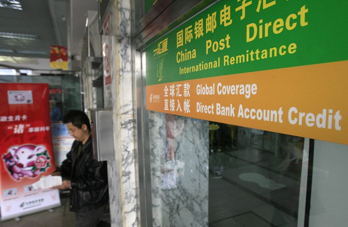 A man emerges from a post office where a Postal Savings Bank of China branch offers remittance service.