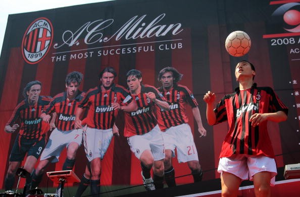 A soccer fan performs football skills in front of a billboard featuring AC Milan players on May 10, 2008 in Nanjing of Jiangsu Province, China.