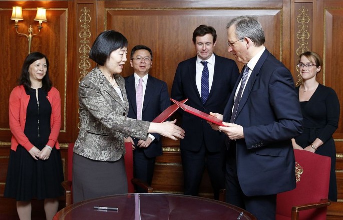 Deputy Governor of the PBOC Hu Xiaolian and Deputy Governor of the Bank of England John Cunliffe shake hands after signing the MoU on renminbi clearing and settlement in London in March 2014.