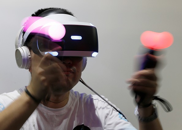  A visitor wearing a PlayStation VR headset plays a video game in the Sony Interactive Entertainment Inc. booth.