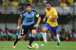 Uruguay striker Luis Suárez competes for the ball against Brazil's Renato Augusto.
