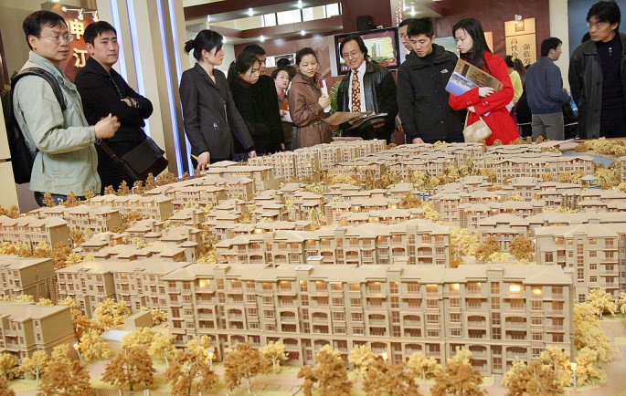 Prospective buyers look at an estate plan by a local developer at a property exhibition in Shanghai.