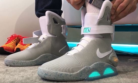 A guy tries on the new self-lacing Nike Mags shoes.