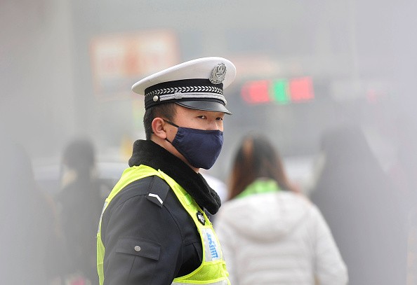 A policeman wears a face mask while directing traffic on Dec. 9, 2015, in Taiyuan, Shanxi Province of China. 