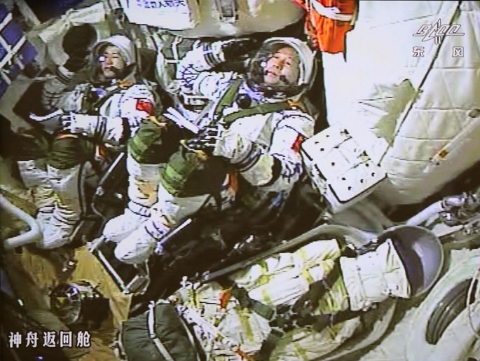 Astronauts Jing Haipeng and Chen Dong salute as China's Shenzhou-11 spacecraft prepares to launch on Oct. 17.