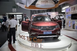 Visitors take a look at the Rowe RX5009, a sports utility vehicle (SUV) built by SAIC and integrated with Alibaba Group's YunOS, during the Mobile World Congress Shanghai in Shanghai in June 2016.