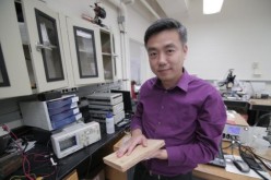 Associate Professor Xudong Wang holds a prototype of the researchers' energy harvesting technology, which uses wood pulp and harnesses nanofibers.