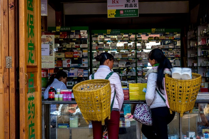 Two local women buy medicines at a pharmacy in Shanxi.