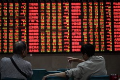 Investors watch the boards at a trading stock hall in Nanjing in Jiangsu Province.