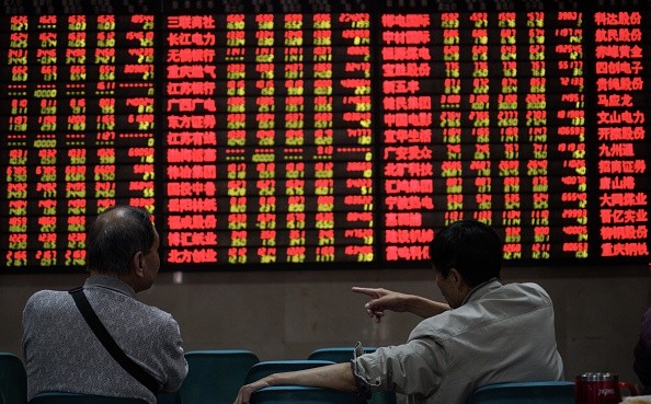Investors watch the boards at a trading stock hall in Nanjing in Jiangsu Province.
