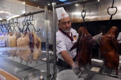 A chef prepares a Peking duck to be served to customers in a Beijing restaurant.