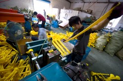 Workers sort out materials at a plastics factory in Nongbo in Zhejiang Province.