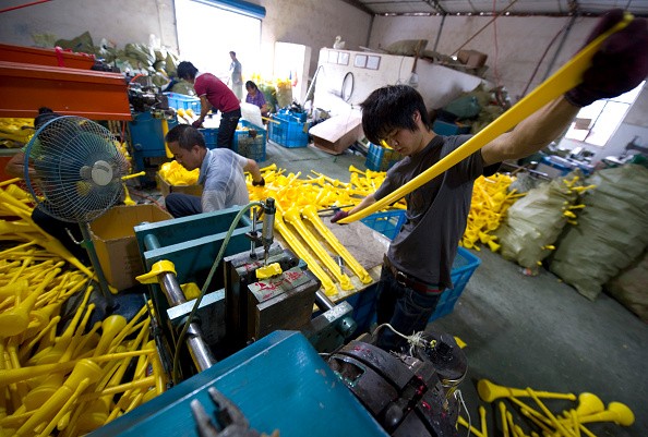 Workers sort out materials at a plastics factory in Nongbo in Zhejiang Province.