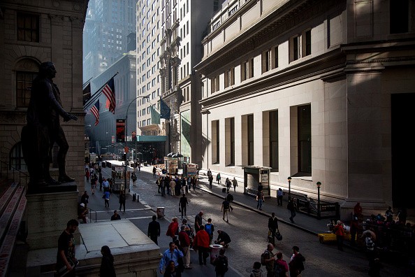People walk near the New York Stock Exchange on Wall Street.