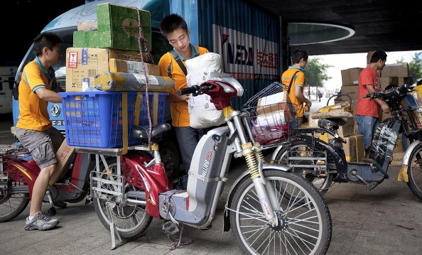 A courier loads packages for delivery using an electric bicycle in Shenzhen, Guangdong Province.