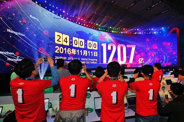 Alibaba's staff take photos of the screen showing the company's sales figure during last Friday's Singles' Day event.