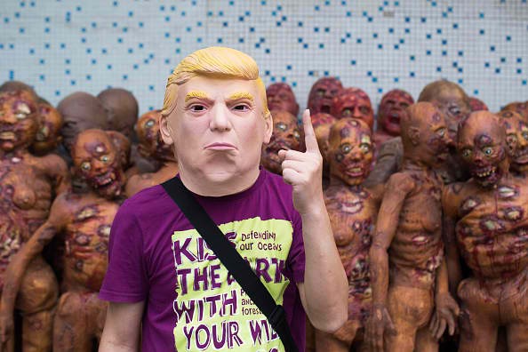A man wears a Trump mask made in a factory in Shenzhen. 
