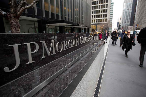 Pedestrians walk past a signage of JPMorgan in its headquarters in New York.