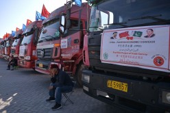 A Chinese worker waits near trucks carrying goods during the opening of a trade project in Gwadar port.