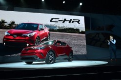 New Toyota C-HR  SUV on the display for introduction as a senior staff member takes a look at it cheerfully