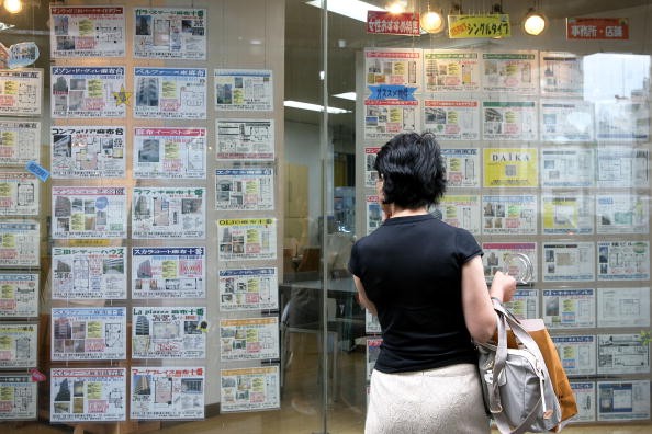 A woman looks at property details in front of a real estate agency on July 10, 2009, in Tokyo, Japan.
