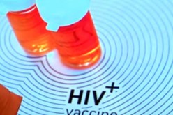 Two medicine bottles are placed just above an HIV positive vaccine sign. 